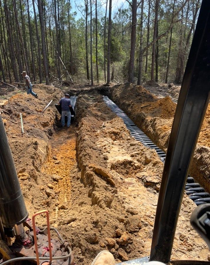 Drainage pipe installation on a wooded property
